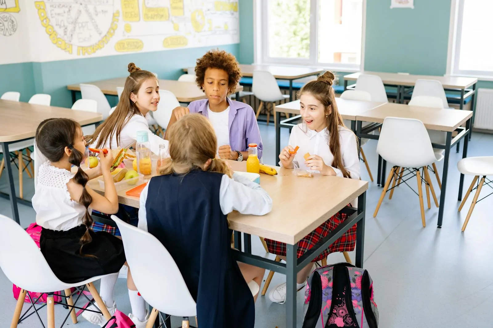 Schoolchildren eating lunch together at a classroom table